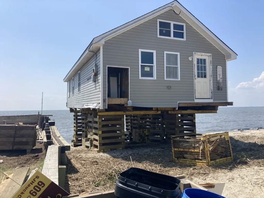 A house elevated on stilts near the water.